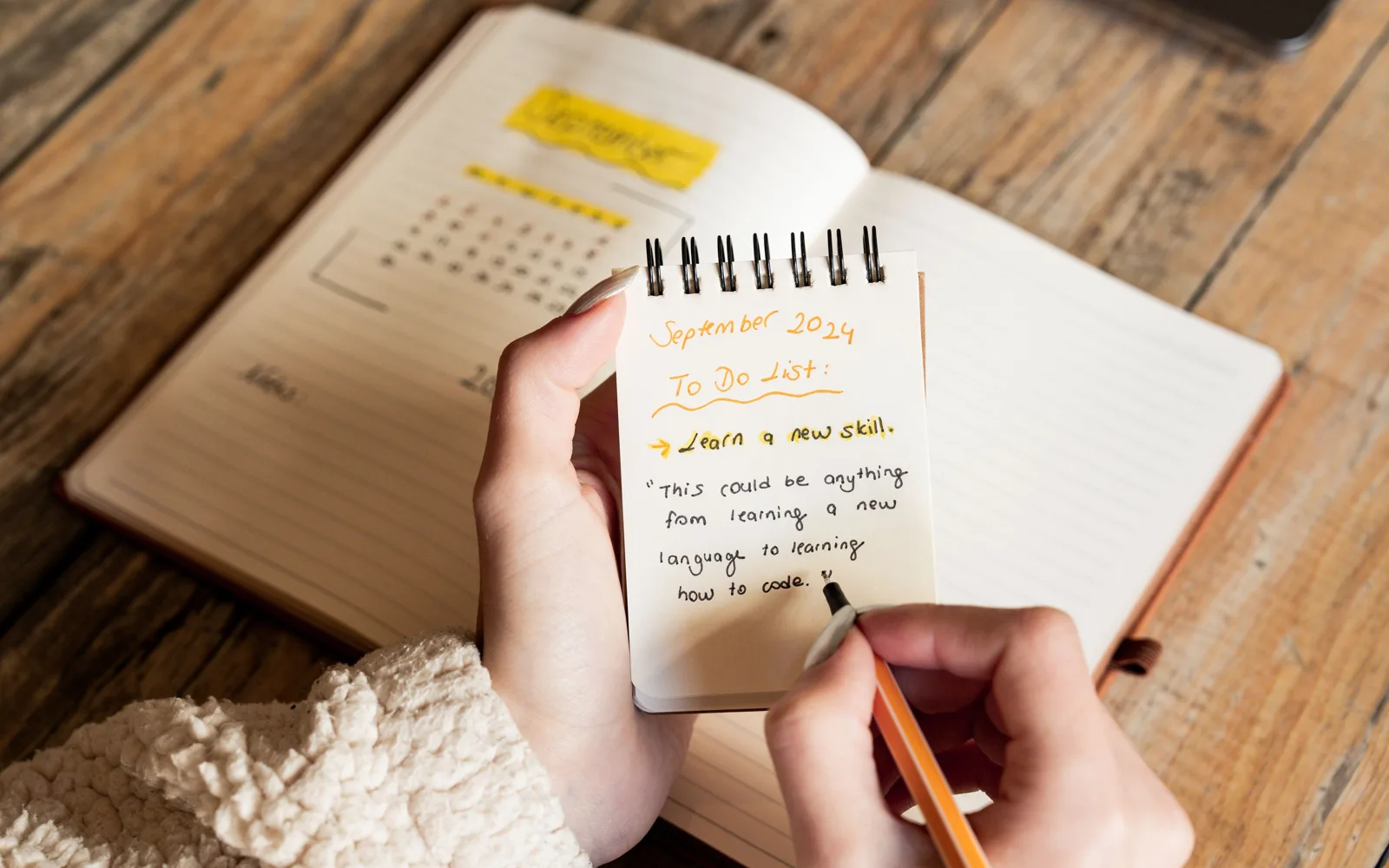 Une personne écrit la liste de ses objectifs dans un carnet d’atelier